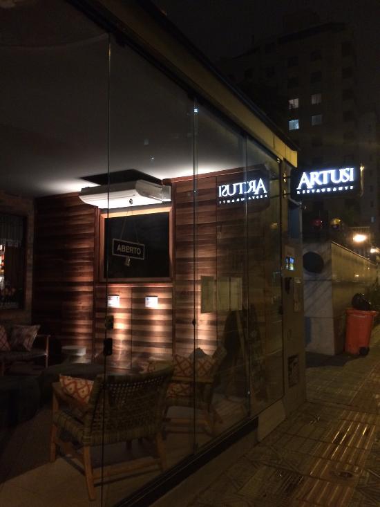 Fachada do restaurante Artusi, no Centro de Florianópolis, iluminada à noite.