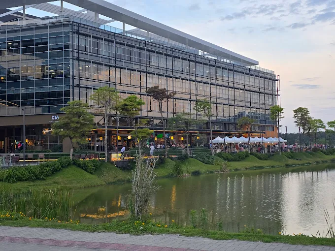 Vista aérea do Sapiens Parque, em Florianópolis — prédios brancos modernos rodeados pela Mata Atlântica.